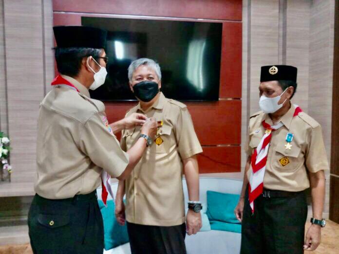 Bupati Pinrang H. Irwan Hamid menerima dua lencana yang diserahkan Ketua kwartir Pramuka Pinrang, Drs. Darwis Bastama
