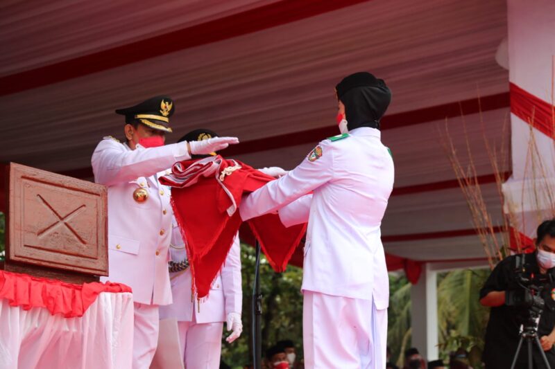 Bupati Wajo H. Amran Mahmud menyerahkan bendera merah putih kepada Paskibrak untuk dikibarkan