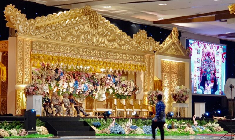 Acara resepsi pernikahan di hotel mewah di Makassar tak lagi menyiapkan kursi tempat duduk, sehingga para tamu hanya naik ke panggung memberi  ucapan selamat dengan tidak bersalaman langsung kepada pasangan pengantin demi untuk protokol kesehatan
