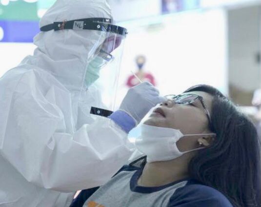 Petugas Klinik Bandara memeriksa tes PCR salah seorang calon penumpang di bandara.