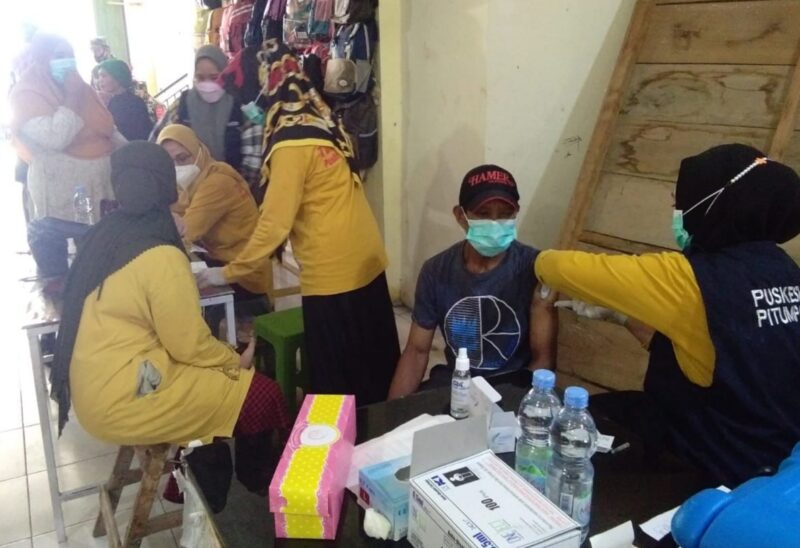 Tim Vaksinator Puskesmas Pitumpanua berkerjasama dengan Polsek Urban Pitumpanua, Koramil 1406-10/ Pitumpanua melakukan vaksinasi massal di Pasar Sentral Siwa