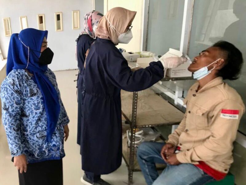 Salah seorang pekerja migrasi asal Cianjur Jawa Barat dites PCR sebelum diberangkatkan dengan kapal laut ke daerah asalnya.(nadiyah)