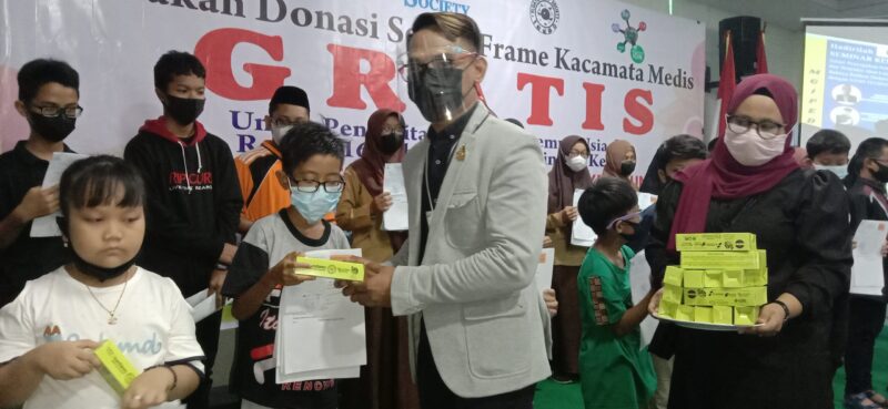 Manager Marketing MGI Febriansyah menyerahkan donasi Kacamata Medis kepada remaja umur 16 tahun ke bawah minus 5 keatas.