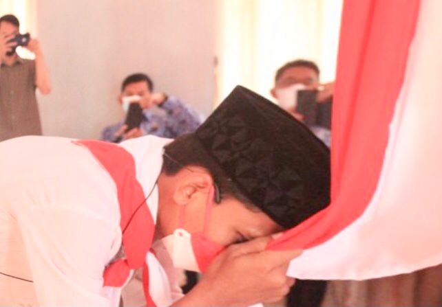 Napi teroris Lapas Kelas I Makassar mencium Bendera Merah Putih setelah  berikrar setia kepada NKRI.(humas)