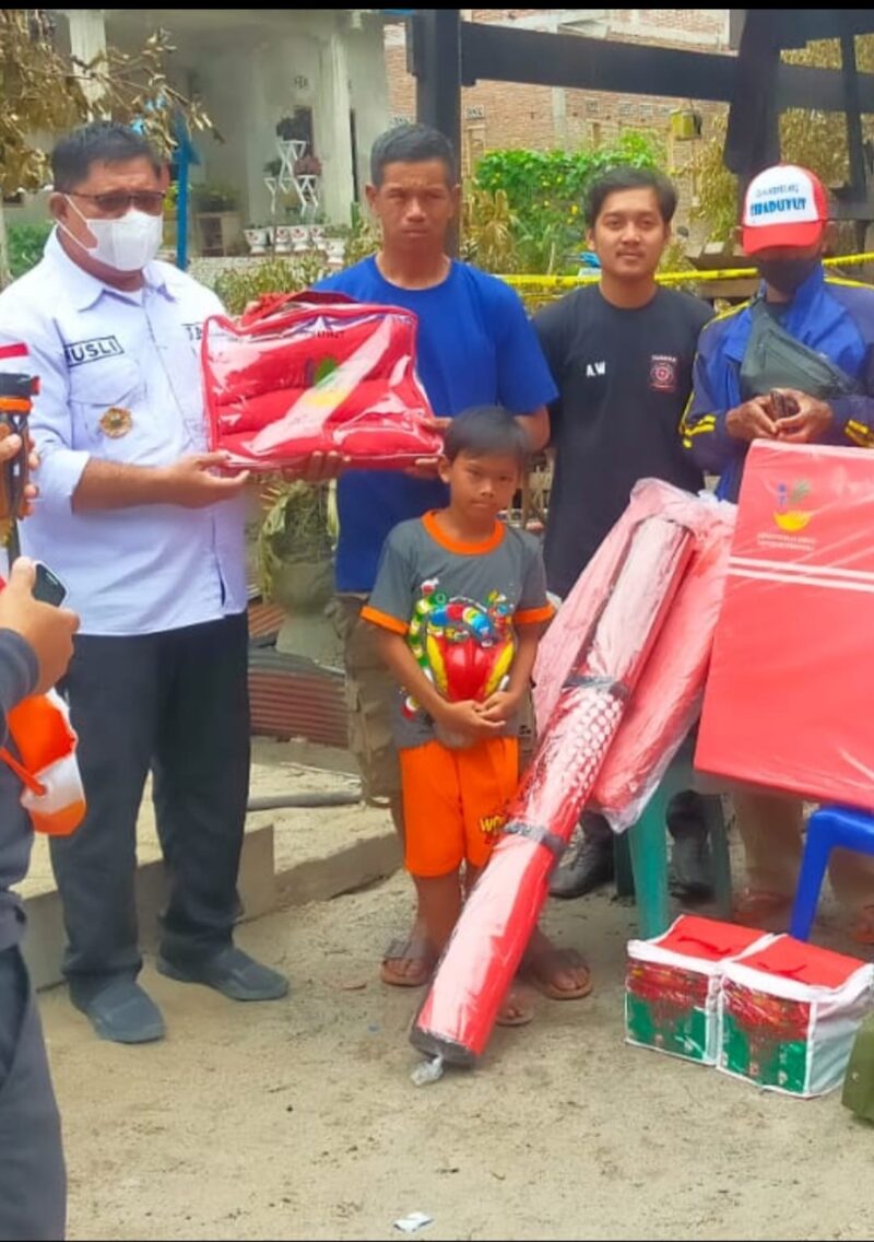 Kadis Sosial didampingi Camat patampanua meyerahkan bantuan kepada korban kebakaran