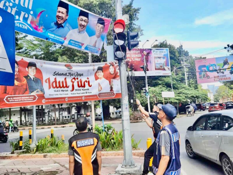 Personil Dinas Perhubungan (Dishub) Kota Makassar Bidang Sarana dan Prasarana (Sarpras) Mencabut Spanduk yang Menempel di Tiang Traffic Light, di Beberapa Ruas Jalan di Kota Makassar, Rabu 18 Mei 2022.