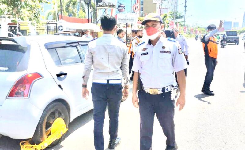 Dinas Perhubungan (Dishub) Makassar, Menggembok Kendaraan Roda Empat yang Parkir di Sembarang Tempat, Senin 22 Agustus 2022.