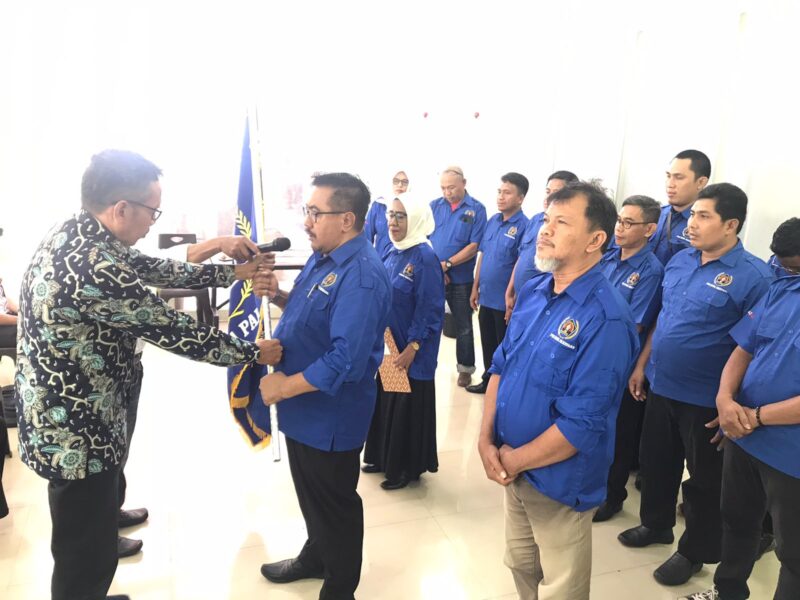 Ketua Bidang Organisasi PWI Sulsel, H Abdul Manaf Rachman (kiri) Menyerahkan bendera petaka kepada Abdul Razak Arsyad kemudian dikibarkan.