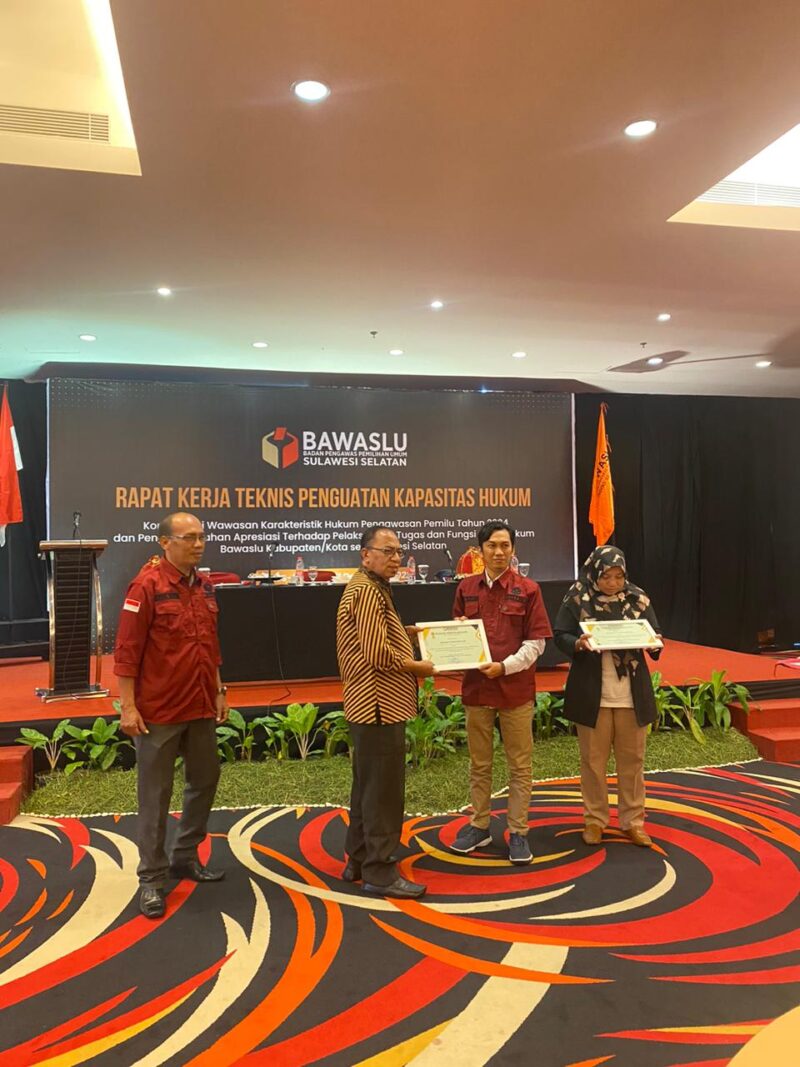  Ketua Bawaslu Provinsi Sulawesi Selatan Drs. HL Arumahi menyerahkan penghargaan kepada Ketua Bawaslu Wajo Dr. Abdul Malik di  Swiss-belhotel Jl. Ujung Pandang No. 8 Bontoala, Kota Makassar, Ahad (11/12/2022)