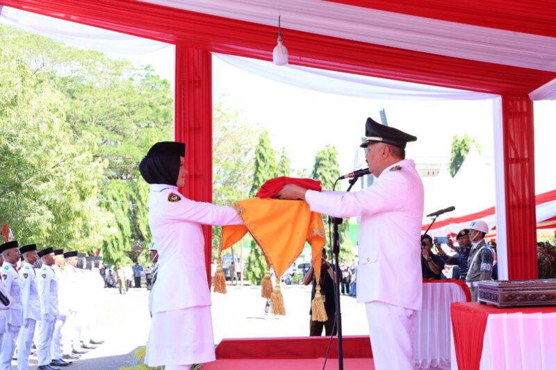Bupati Pinrang selaku inspektur upacara menyerahkan Bendera Merah Putih kepada Paskibraka untuk di kibarkan