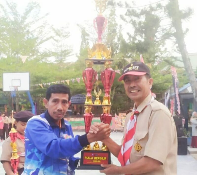 Ketua Kwarcab Pramuka Kabupaten Pinrang Darwis Bastama, saat menyerahkan Piala Juara I Umum kepada Kepala UPT SDN 5 Pinrang Suharto, S.Pd.SD