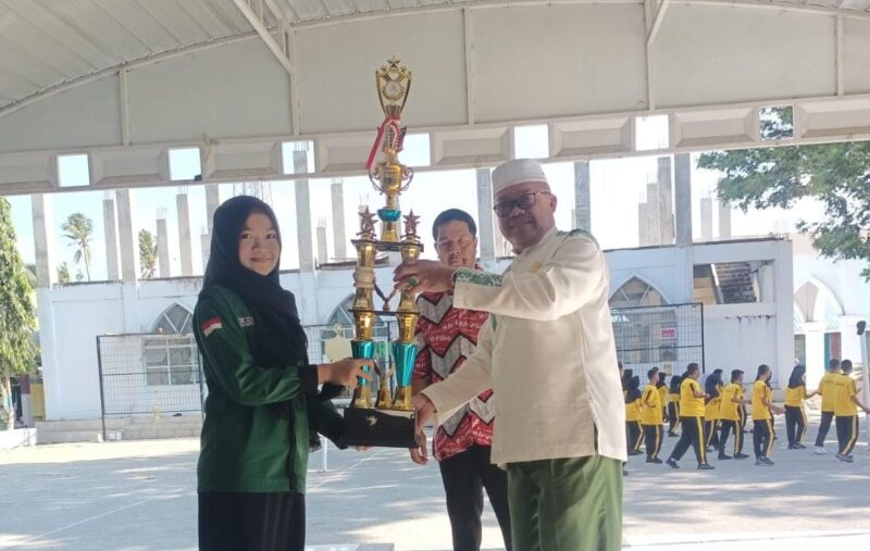Kepala Sekolah SMAN Drs.H. Bahri Bohari, M.Pd. menyerahkan piala bergilir kepada Sekretaris umum HMJ Biologi FMIFA UNM, Amalia Nur Resky (13/10)