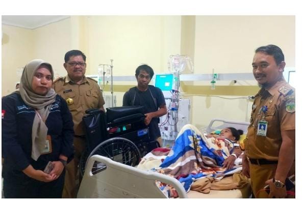 Kadis Sosial Pinrang di dampingi Kepala bidang Rehabilitasi sosial Dinsos, serahkan Bantuan kursi roda kepada Baria salah seorang warga Rajang kecamatan Lembang