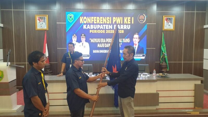 Wakil Ketua Bidang Organisasi PWI Sulsel, Manaf Rachman (kanan) menyerahkan bendera PWI kepada ketua PWI Barru Ahmadi Kalub yang terpilih secara aklamasi dalam konferkab I PWI Barru.