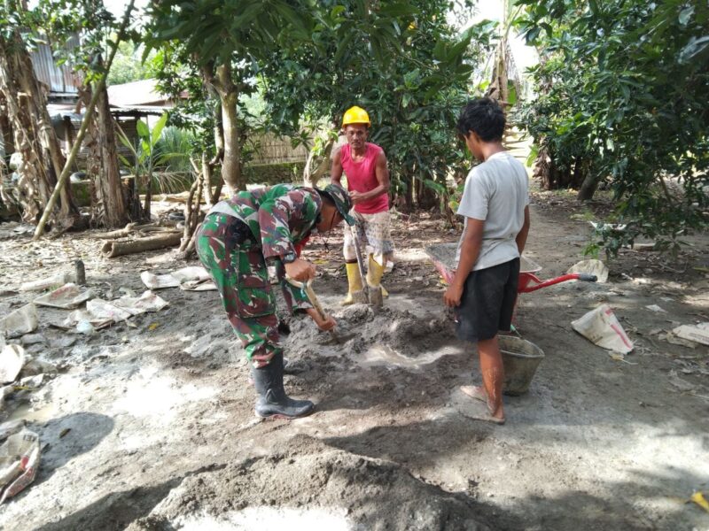 Personel Babinsa Koramil 1406-10/Pitumpanua, Serda Firman, turun langsung membaur bersama warga dalam aksi karya bakti pembersihan ruas jalan desa pada Minggu (8/2/2026)