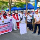 Ketua DPP IARMI Provinsi Sulsel, Drs. H. Bahar Ngitung, MBA mengangkat bendera star untuk melepas peserta gerak jalan santai alumni Unhas.