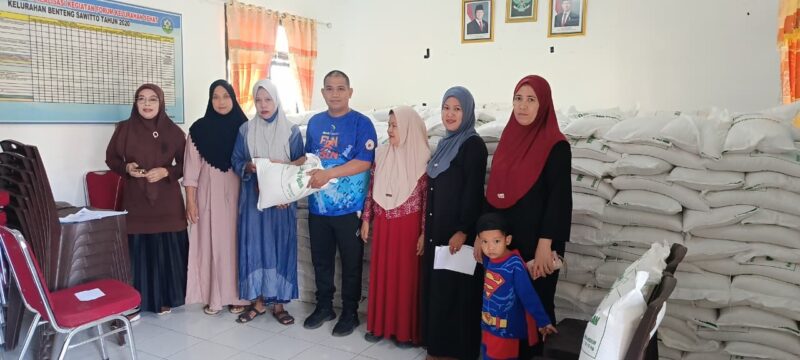 Lurah Benteng Sawitto  Kecamatan Paleteang Suparto, SE, didampingi kasi kesra kelurahan Benteng Sawitto Hj. Fauziah, SE,.MM, menyerahkan bantuan pangan beras kepada warga tidak mampu.