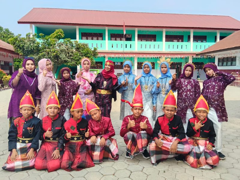 Kepala UPT SDN 240 Pinrang , Suriani Mappa,S.Pd, M.Pd, berpose bersama guru dan siswa usai pelaksanaan upacara peringatan hari sumpah pemuda Ke-98 di halaman sekolah UPT SDN 240 Pinrang.